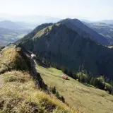 Leichte nagelfluhkette wanderung mit Blick auf grüne Täler und Berge. Ein Weg führt zu kleinen Hütten.