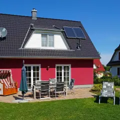 Ferienhaus mit Strandkorb und Gartenmöbeln, ideal für einen entspannten Urlaub an der **Glowe Ostsee**.