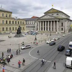 Der Max-Joseph-Platz in München mit dem Nationaltheater und der Residenz. Autos und Fußgänger beleben den Platz.