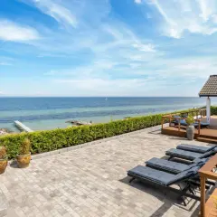 Traumhafter Blick auf den Lohme Strand mit Liegen auf der Terrasse und dem Meer im Hintergrund.