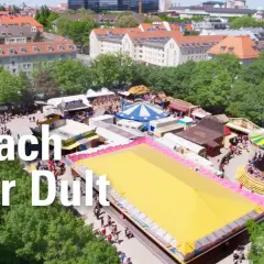 Buntes Treiben auf der Auer Dult mit Karussell, Buden und vielen Besuchern.