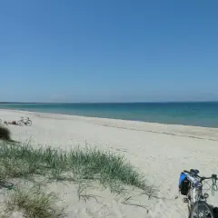 Fahrräder am Strand von Rügen, bereit für eine Tour zur Schaabe. Sonnenschein und Meer laden zum Entspannen ein.