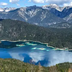 Blick vom Eibsee zur Zugspitze: Türkisblaue Wasserflächen, bewaldete Hänge und schneebedeckte Gipfel. Ein Traumziel für Wanderer.