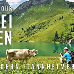 Bergwanderung zur drei Seen Tour im Tannheimer Tal. Ein Wanderer mit Rucksack und Stöcken kniet am Ufer eines smaragdgrünen Sees.