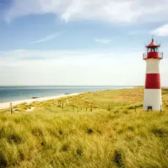 Leuchtturm am Strand mit Dünen, ein **Geheimtipp Urlaub August Deutschland**.