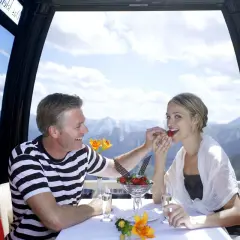Ein Paar genießt Erdbeeren in einer Gondel mit Bergblick. Eine romantische Idee, was man zu zweit unternehmen kann.