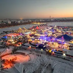 Winterzauber auf dem weihnachtsmarkt theresienwiese. Bunte Lichter, Schnee und Menschenmassen unter Zelten und Lichtern.