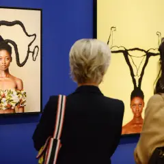 Besucher betrachten Kunstwerke bei der ausstellung hypo kunsthalle. Ein Bild zeigt eine Frau mit afrikanisch geformten Haaren, das andere eine Frau mit Gebärmutter-Frisur.