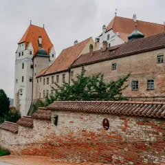 Die Trausnitz Burg in Landshut, ein Ort voller Geschichte und Geheimtipps, mit ihren roten Ziegeldächern und dem markanten weißen Turm.