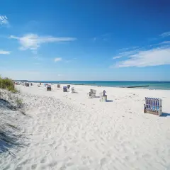 Ein perfekter Hiddensee Urlaub: Weißer Sandstrand, blaue Ostsee und Strandkörbe laden zum Entspannen ein.