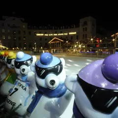 Bunte Eisbären-Figuren am Stachus Weihnachtsmarkt in München, mit Lichtern und einer Eisbahn im Hintergrund.