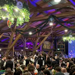 Volles Festzelt beim Starkbierfest mit Band auf der Bühne und vielen Gästen in traditioneller Kleidung.
