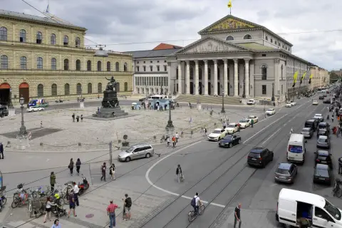 Der Max-Joseph-Platz in München mit dem Nationaltheater und der Residenz. Autos und Fußgänger beleben den Platz.