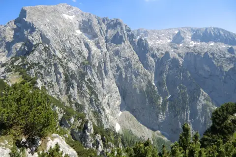 Majestätische Bergkulisse mit felsigen Hängen und grünen Nadelbäumen, ideal für eine Kehlsteinhaus Wanderung.