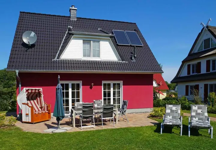 Ferienhaus mit Strandkorb und Gartenmöbeln, ideal für einen entspannten Urlaub an der **Glowe Ostsee**.