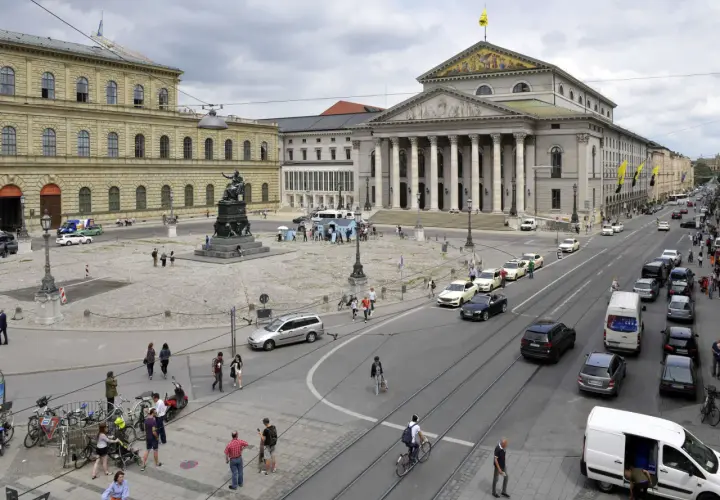 Der Max-Joseph-Platz in München mit dem Nationaltheater und der Residenz. Autos und Fußgänger beleben den Platz.