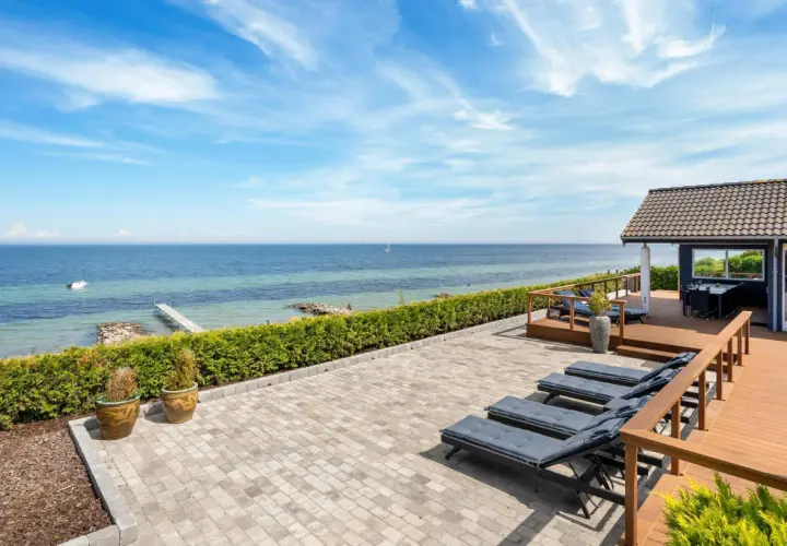 Traumhafter Blick auf den Lohme Strand mit Liegen auf der Terrasse und dem Meer im Hintergrund.