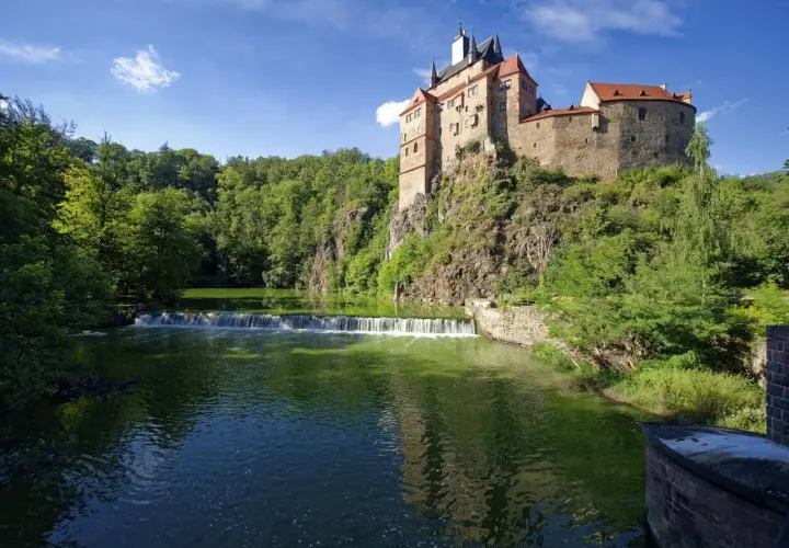 Burg Kriebstein, ein malerisches Schloss auf einem Felsen über einem Fluss mit Wasserfall, ist ein tolles Ziel für Ausflugsziele Sachsen.