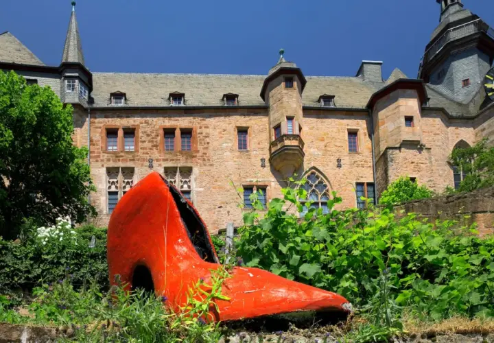 Ein riesiger roter Schuh vor dem Marburger Schloss – ein ungewöhnlicher Anblick, der zeigt, was man in Marburg machen kann: Kunst entdecken!