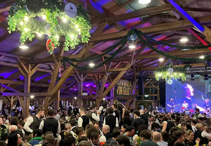 Volles Festzelt beim Starkbierfest mit Band auf der Bühne und vielen Gästen in traditioneller Kleidung.