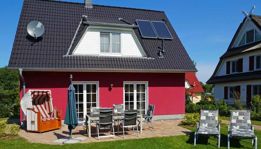 Ferienhaus mit Strandkorb und Gartenmöbeln, ideal für einen entspannten Urlaub an der **Glowe Ostsee**.
