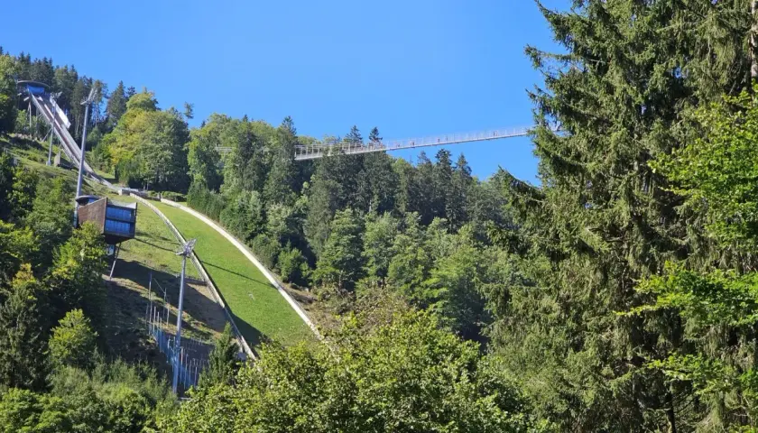 Der Skywalk Willingen überspannt den Wald und bietet einen atemberaubenden Blick auf die Sprungschanze und die grüne Landschaft.