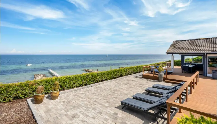Traumhafter Blick auf den Lohme Strand mit Liegen auf der Terrasse und dem Meer im Hintergrund.