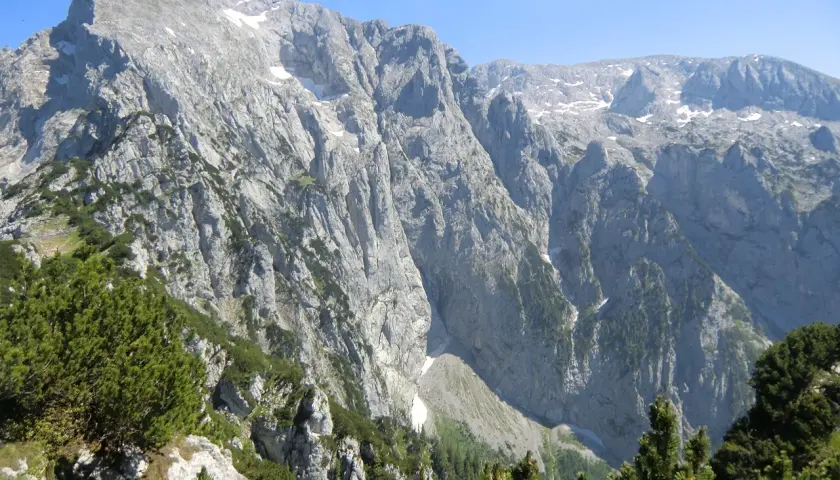 Majestätische Bergkulisse mit felsigen Hängen und grünen Nadelbäumen, ideal für eine Kehlsteinhaus Wanderung.