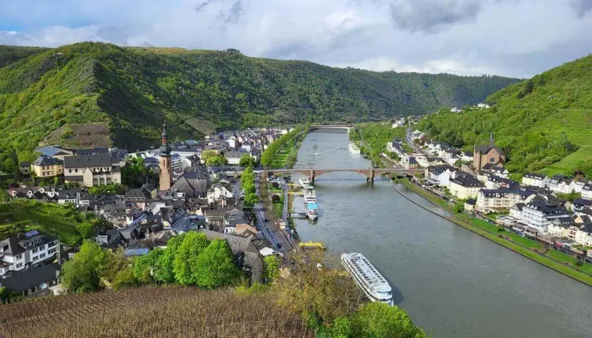 Blick vom Panoramaweg Cochem auf die Mosel, die Stadt mit ihren Kirchen und die steilen Weinberge.