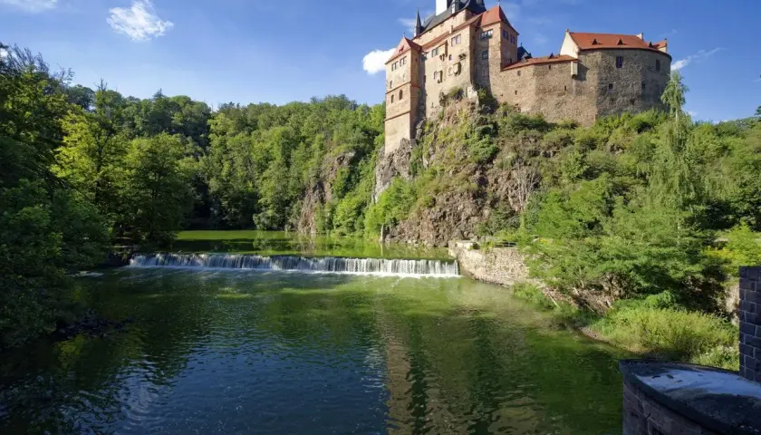 Burg Kriebstein, ein malerisches Schloss auf einem Felsen über einem Fluss mit Wasserfall, ist ein tolles Ziel für Ausflugsziele Sachsen.