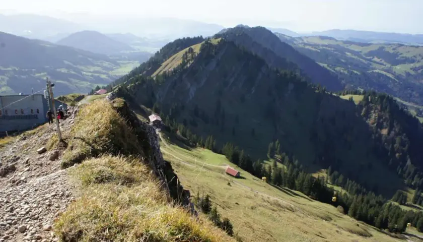 Leichte nagelfluhkette wanderung mit Blick auf grüne Täler und Berge. Ein Weg führt zu kleinen Hütten.