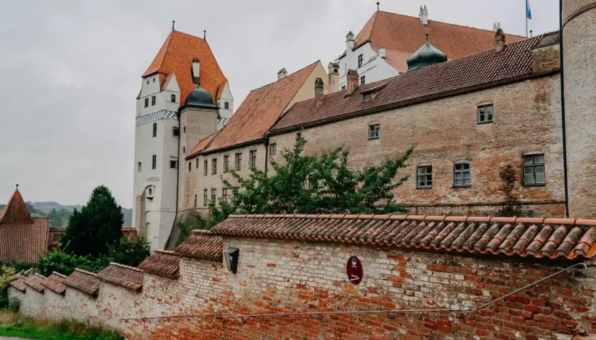 Die Trausnitz Burg in Landshut, ein Ort voller Geschichte und Geheimtipps, mit ihren roten Ziegeldächern und dem markanten weißen Turm.