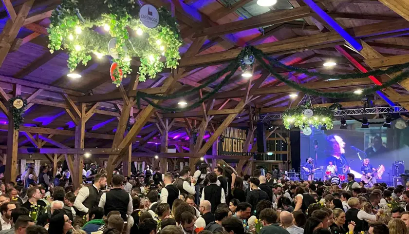 Volles Festzelt beim Starkbierfest mit Band auf der Bühne und vielen Gästen in traditioneller Kleidung.