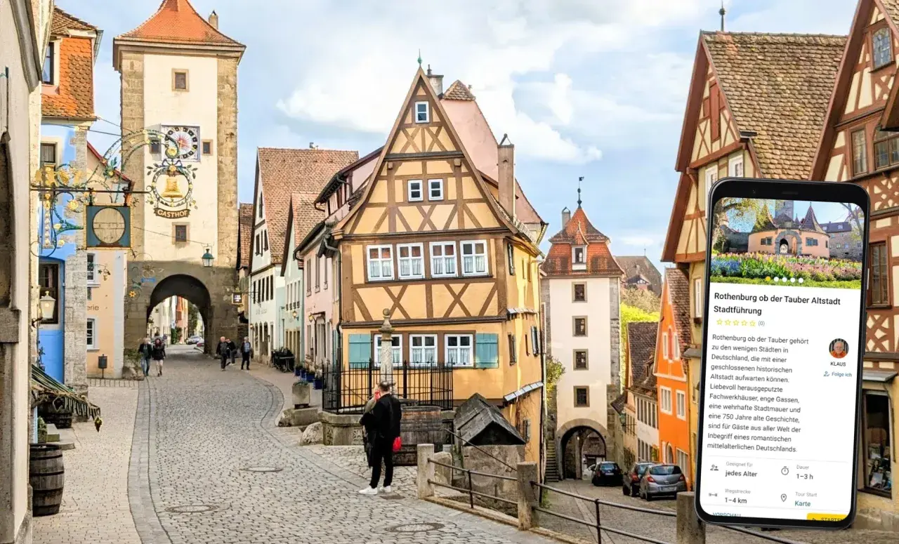 Romantische Gassen und Fachwerkhäuser in Rothenburg ob der Tauber. Ein Smartphone zeigt eine Stadtführung an.
