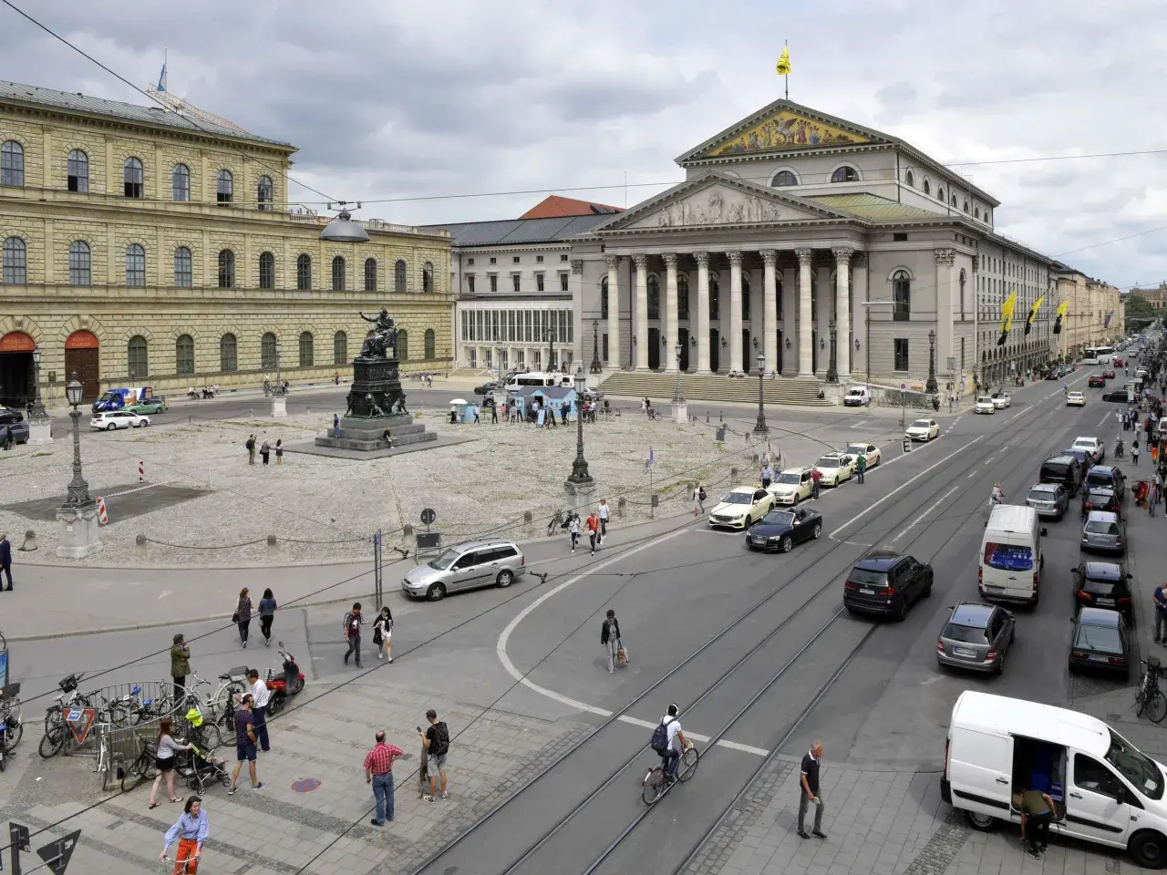 Der Max-Joseph-Platz in München mit dem Nationaltheater und der Residenz. Autos und Fußgänger beleben den Platz.