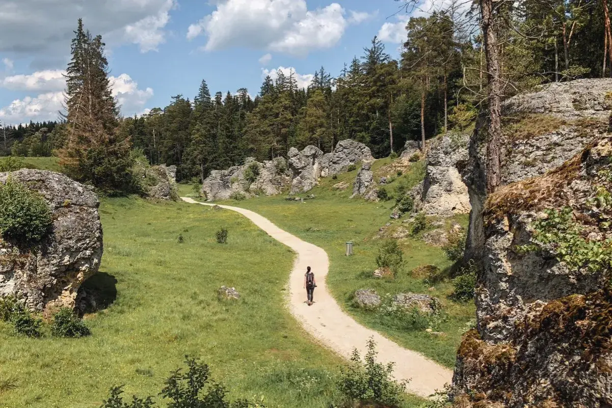 Ein einsamer Wanderer auf einem Pfad durch eine Felsenlandschaft. Ein echter **Geheimtipp Ostdeutschland** für Naturliebhaber.