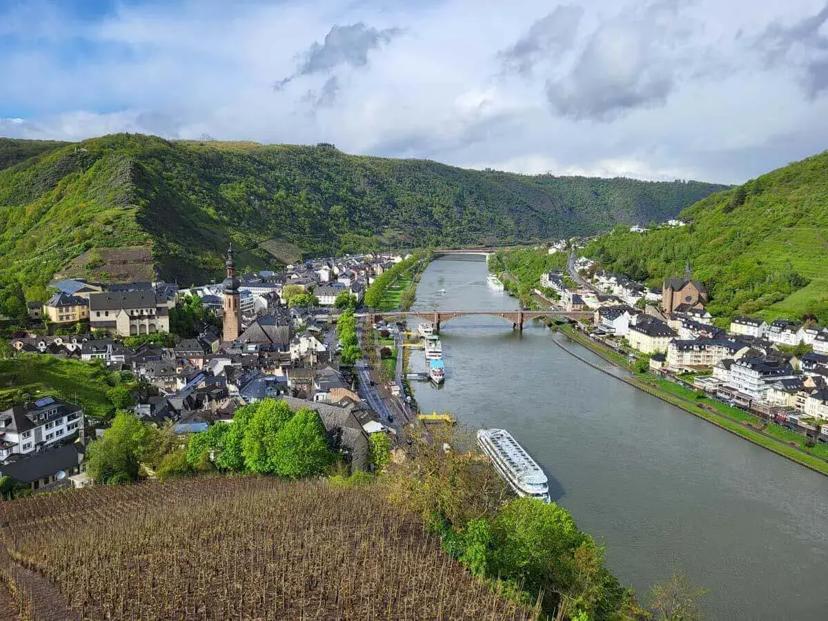Blick vom Panoramaweg Cochem auf die Mosel, die Stadt mit ihren Kirchen und die steilen Weinberge.