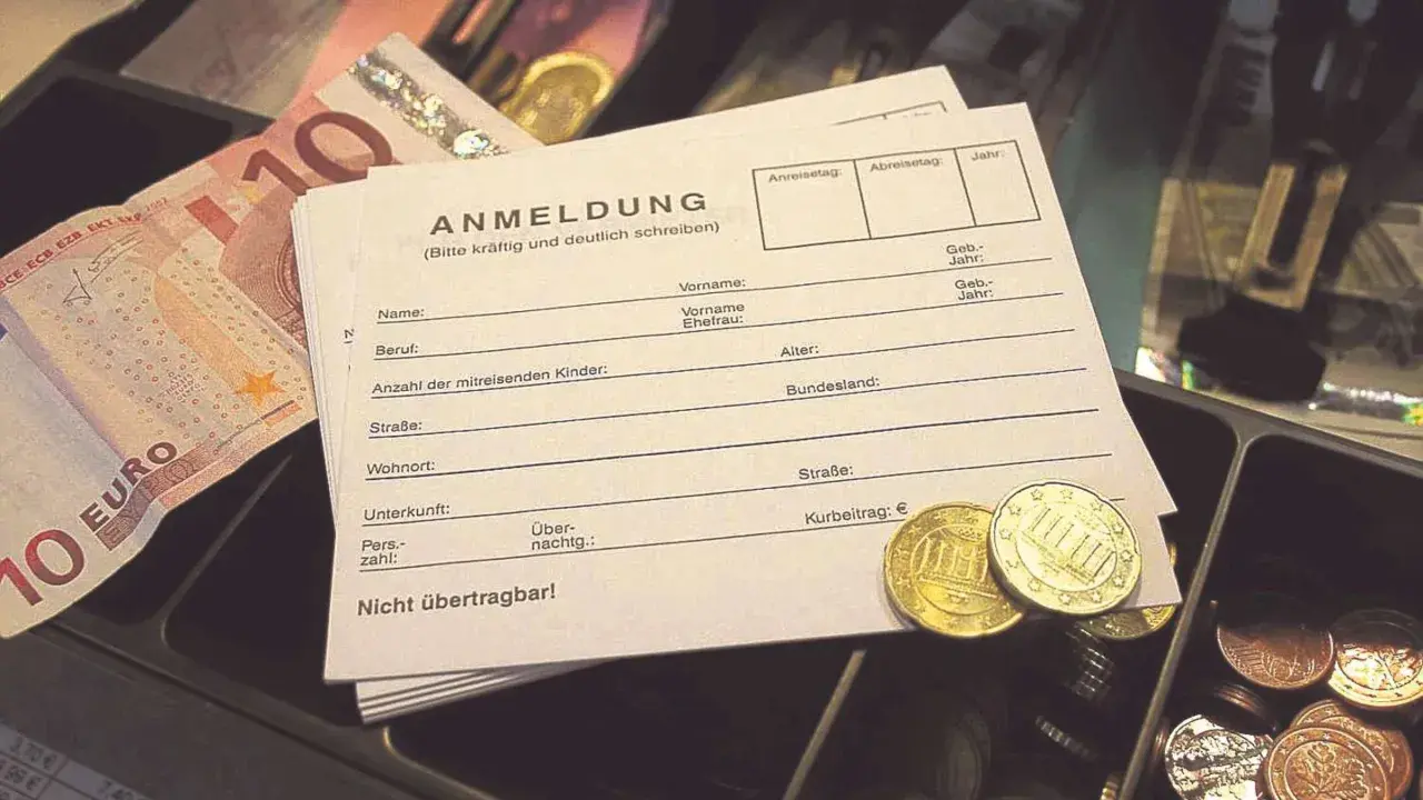 Anmeldeformular mit Euro-Scheinen und Münzen. Hier wird der Kurbeitrag für die Kurtaxe bei Schwerbehinderung eingetragen.