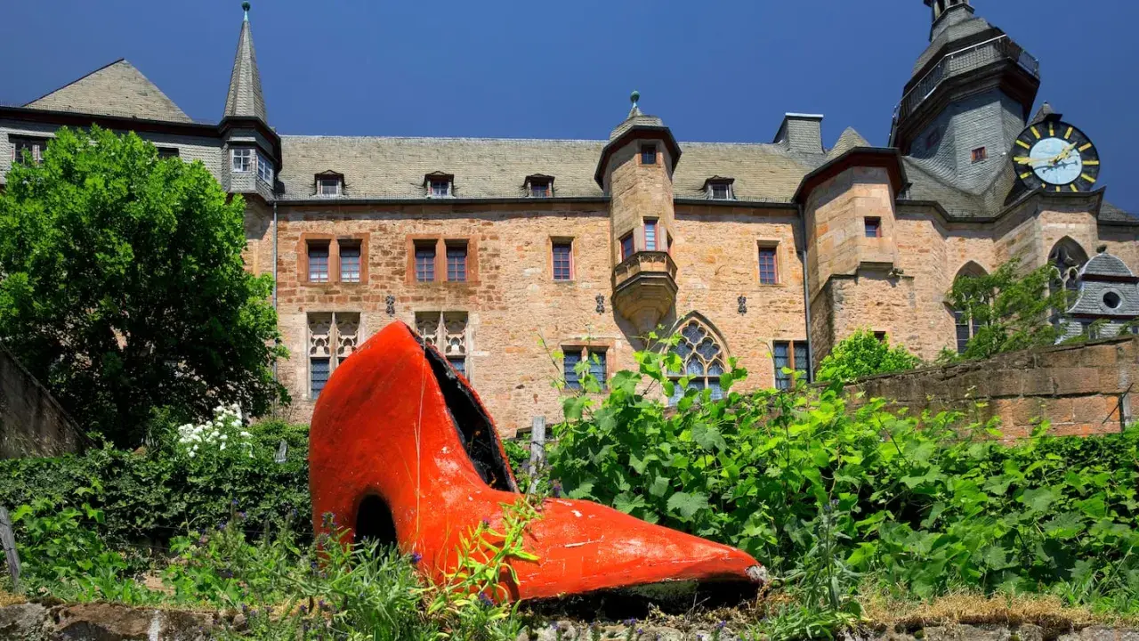 Ein riesiger roter Schuh vor dem Marburger Schloss – ein ungewöhnlicher Anblick, der zeigt, was man in Marburg machen kann: Kunst entdecken!