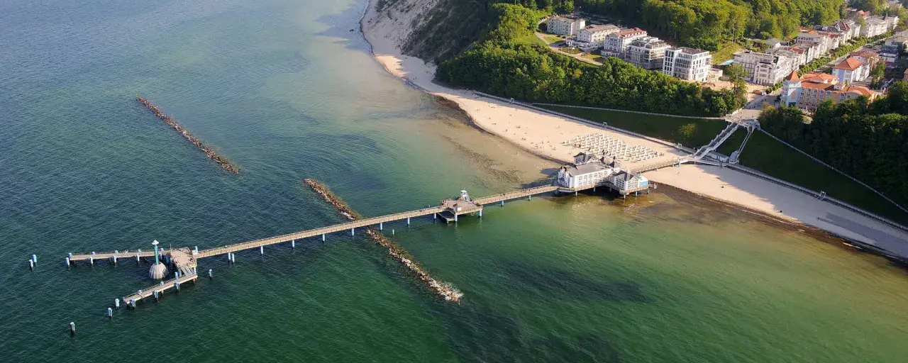 Sellin Ostsee: Blick auf die Seebrücke mit dem Kurhaus, den Strand und die Bäderarchitektur-Häuser.
