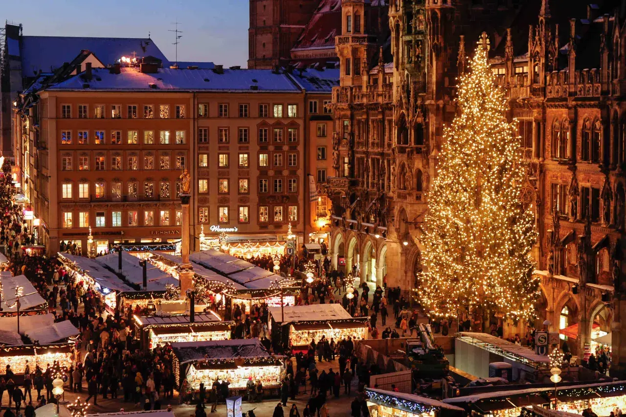 Ein belebter weihnachtsmarkt ostbahnhof mit einem riesigen, funkelnden Weihnachtsbaum und vielen Buden.