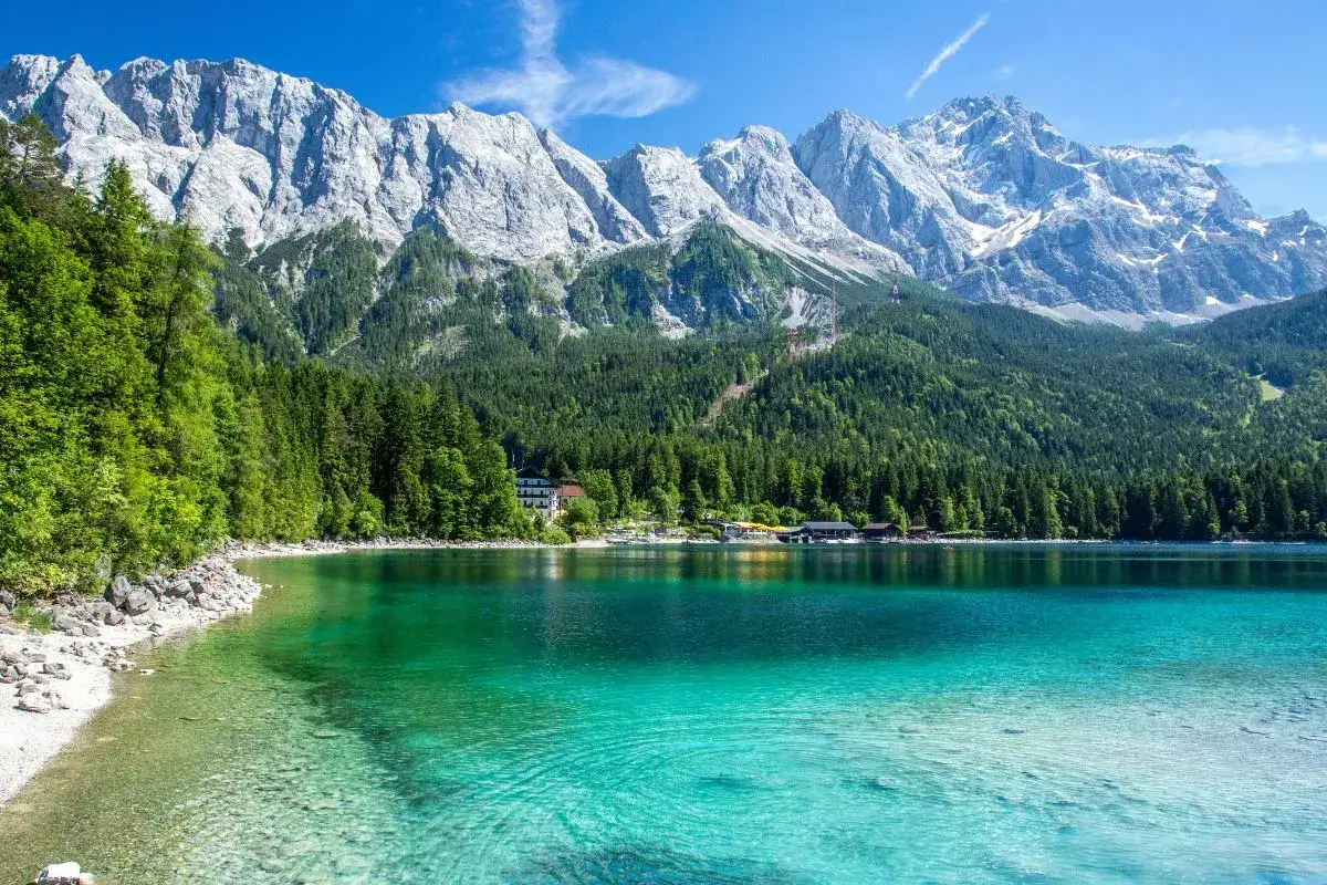 T&uuml;rkisblaue Bergseen mit Felsk&uuml;ste und bewaldeten H&auml;ngen, ein Traumziel f&uuml;r top Urlaubsorte.