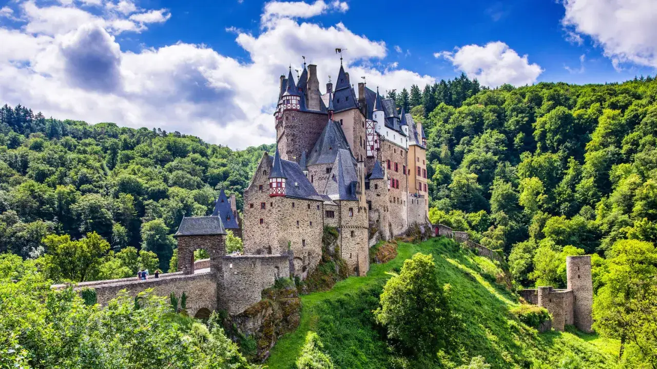 Märchenschloss Eltz, ein Juwel unter den Reiseziele Ostdeutschland, thront auf einem Hügel, umgeben von sattgrünen Wäldern.