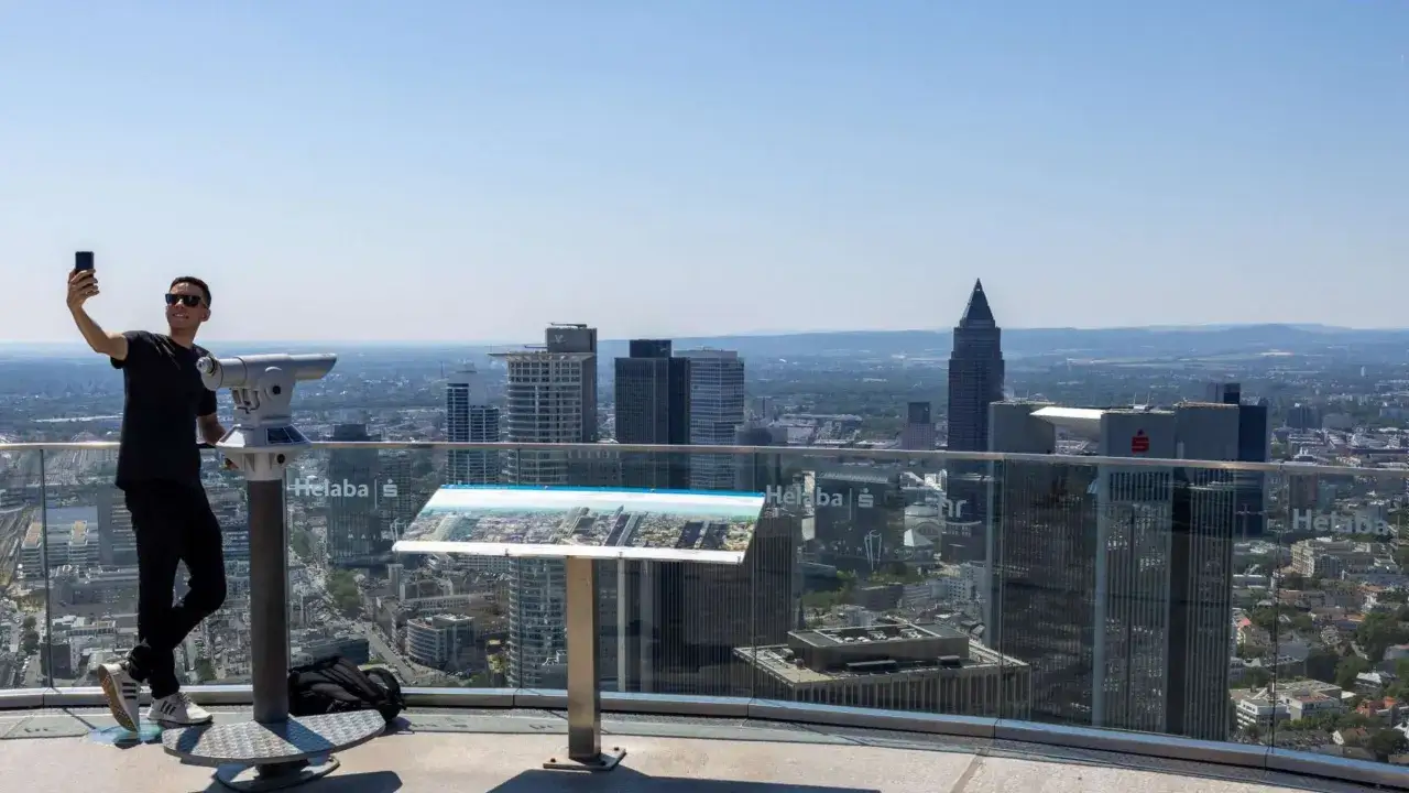 Mann macht Selfie auf der Frankfurt Aussichtsplattform mit Fernrohr und Panoramablick über die Stadt.