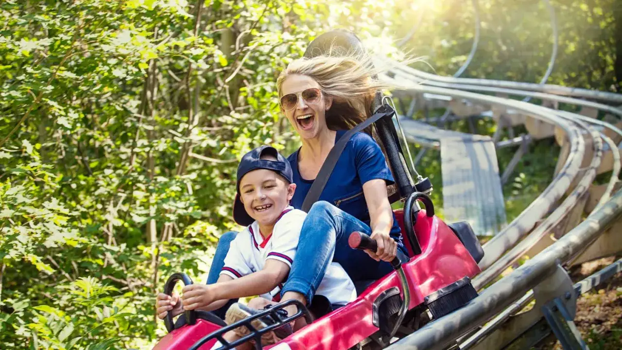 Mutter und Sohn haben Spaß auf einer Rodelbahn, ein tolles Ziel für Ausflugsziele Deutschland mit Kindern.