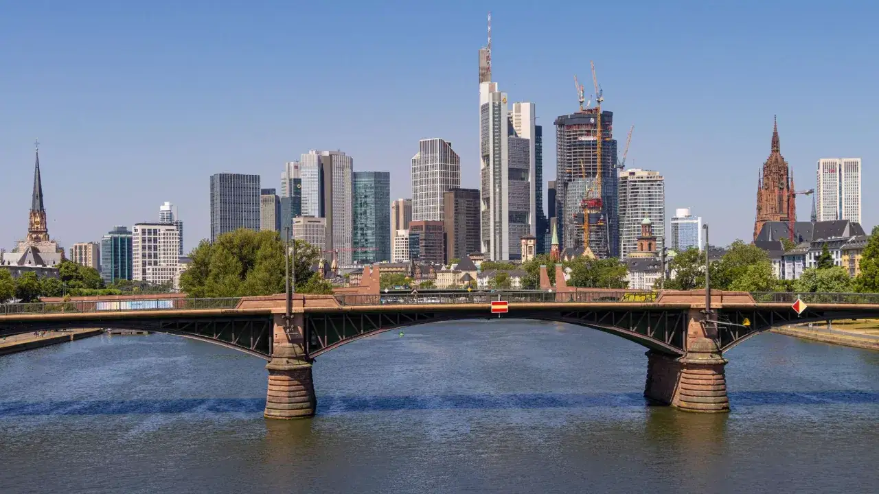 Blick von einer Aussichtsplattform in Frankfurt auf die Skyline mit dem Main und einer Brücke.