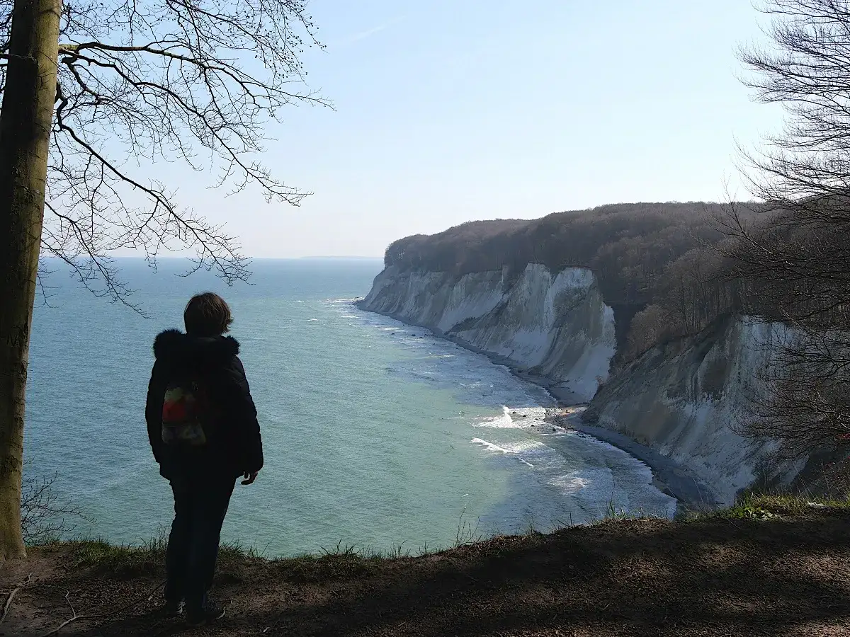 Blick auf die Kreidefelsen bei Sassnitz. Ein Wanderer genie&szlig;t die Aussicht auf das Meer. Ein Muss f&uuml;r Sassnitz Tourismus.