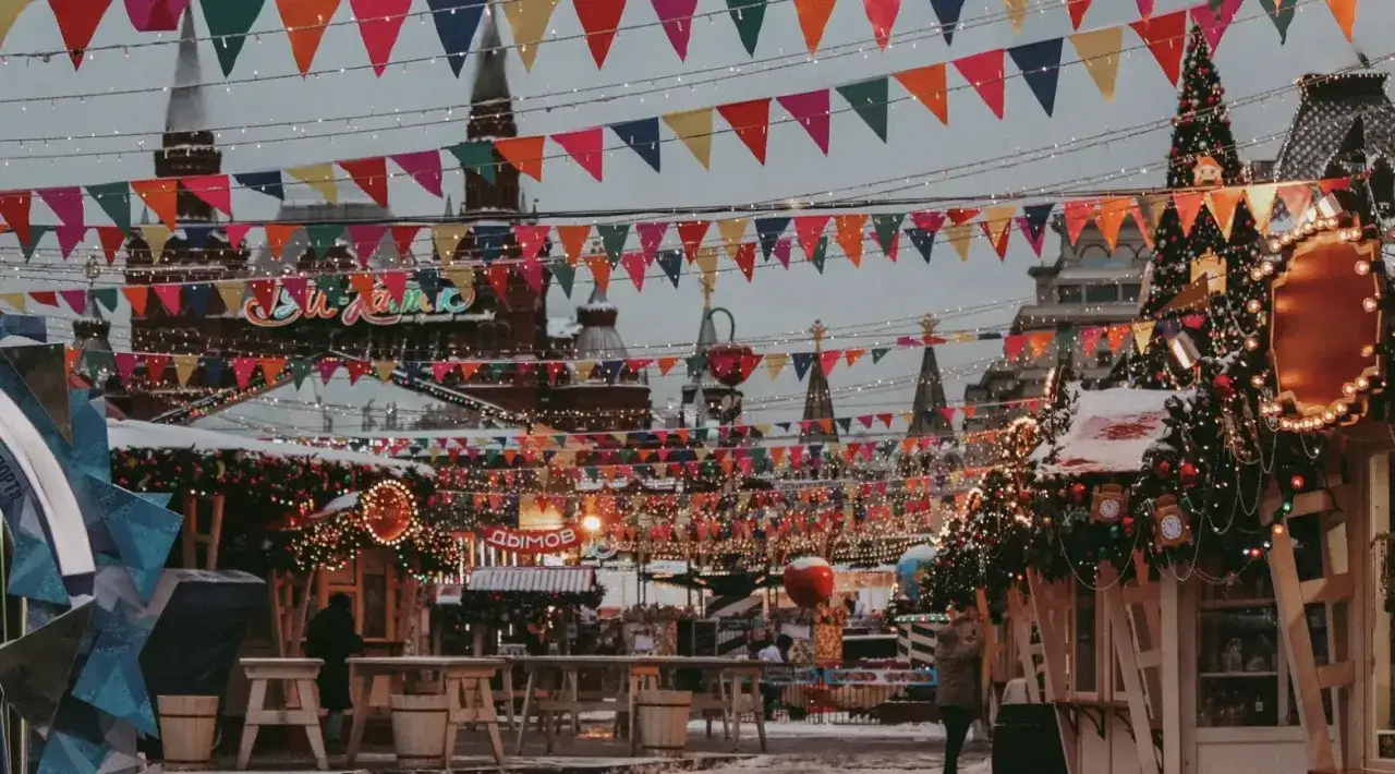 Bunter weihnachtsmarkt ostbahnhof mit Lichterketten und Fahnen. Weihnachtsbäume und Buden laden zum Bummeln ein.