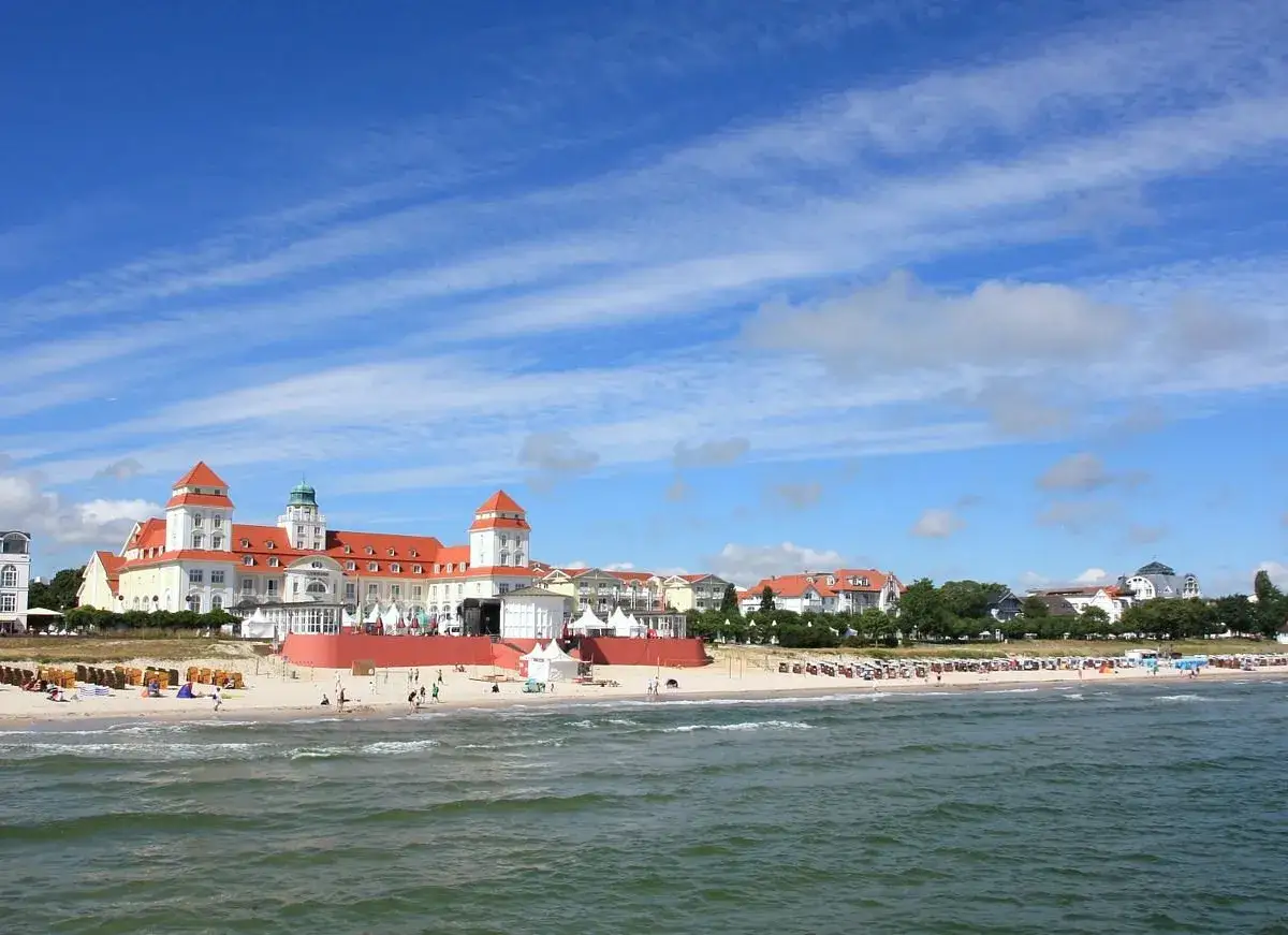 Das Ostseebad Binz mit seiner pr&auml;chtigen B&auml;derarchitektur und dem belebten Strand unter blauem Himmel.