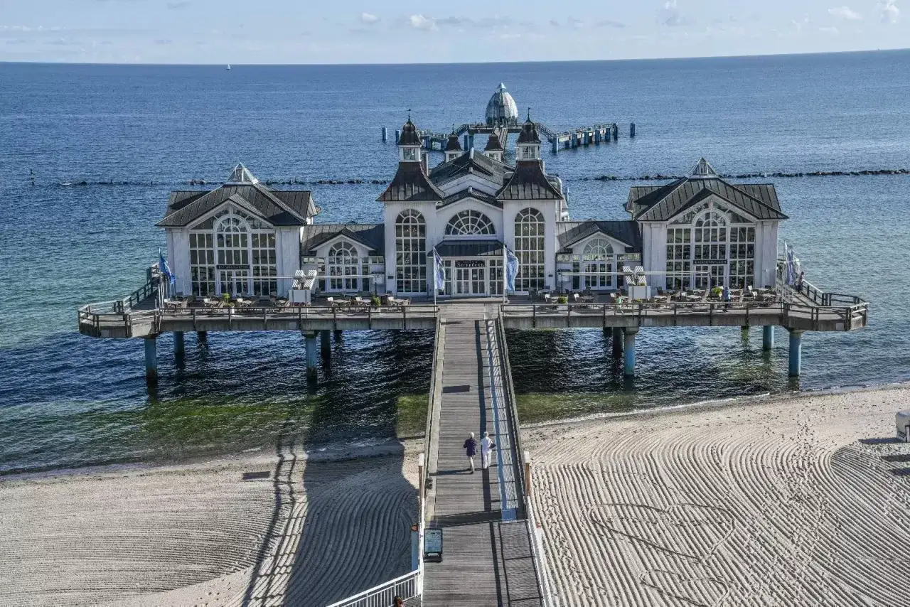 Sellin Ostsee: Die ber&uuml;hmte Seebr&uuml;cke mit dem wei&szlig;en Geb&auml;ude und dem langen Holzsteg, der zum Strand f&uuml;hrt.